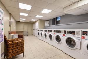 a laundry room with washing machines and a chair at Brookline Studio w Gym nr Green Line BOS-476 in Brookline