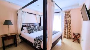 1 dormitorio con cama con dosel en blanco y negro en Evita Beach Suites Exclusivas, en Caleta de Sebo