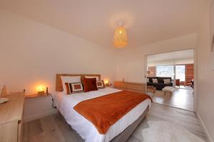 une chambre avec un grand lit et un salon dans l'établissement Le Panoramic - Vue exceptionnelle, à Gérardmer