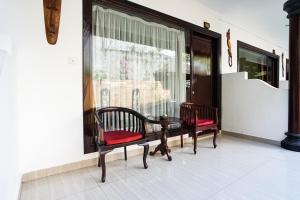 a porch with two chairs and a table and a window at Taman Ayu Legian Hotel in Legian