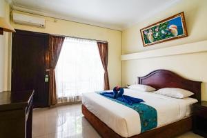 Postel nebo postele na pokoji v ubytování Taman Ayu Legian Hotel