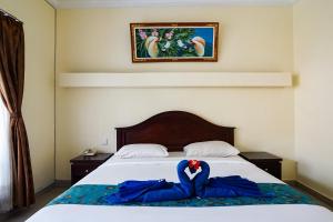 Postel nebo postele na pokoji v ubytování Taman Ayu Legian Hotel