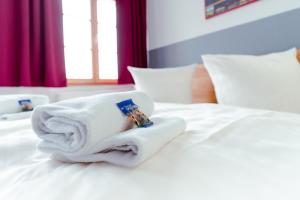 a pile of towels sitting on top of a bed at Restaurant und Pension Alberthafen in Dresden