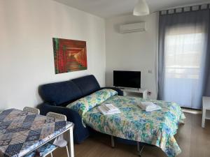 salon z kanapą i telewizorem w obiekcie Panoramic Sport Apartment: vista golfo di Cagliari w Cagliari