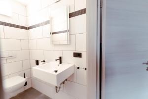 德勒斯登的住宿－Restaurant und Pension Alberthafen，白色的浴室设有水槽和卫生间。