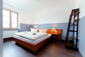 Un dormitorio con una cama con una escalera. en Restaurant und Pension Alberthafen en Dresden