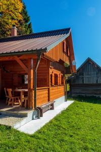 een houten hut met een picknicktafel ervoor bij Holiday house Pokrovec - Bohinj in Bohinj