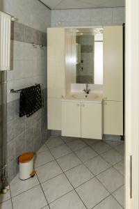 ein Bad mit einem Waschbecken und einem Spiegel in der Unterkunft Zanddijk 113, Julianadorp aan Zee in Julianadorp