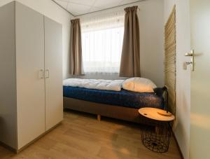 ein kleines Schlafzimmer mit einem Bett und einem Fenster in der Unterkunft Zanddijk 113, Julianadorp aan Zee in Julianadorp
