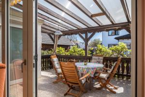 een tafel en stoelen op een patio met een pergola bij Ferienwohnung Luise in Sexau