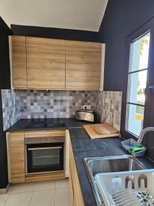 una cocina con armarios de madera y fregadero en Casa Azul Montecastillo L7 en Caleta de Fuste