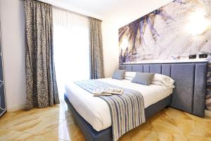 a bedroom with a bed with a painting on the wall at Hotel Oasi Di Kufra in Sabaudia