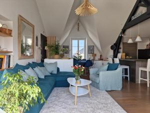 salon z niebieską kanapą i stołem w obiekcie Le Coligny, Appt 100m mer et parking w La Rochelle