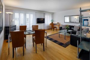 un soggiorno con tavolo, sedie e divano di Aparthotel Familie Hugenschmidt a Zurigo