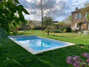 a swimming pool in the yard of a house at Les Romarins B&B, 10 min d'Uzès, piscine et grand jardin, Table d'hôte in Uzès
