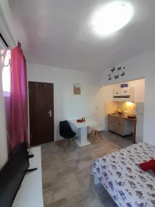 a bedroom with a bed and a table and a kitchen at Apartments Dalamar in Babino Polje