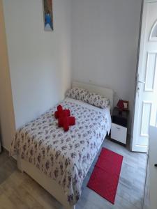 - une chambre dotée d'un lit avec un archet rouge dans l'établissement Apartments Dalamar, à Babino Polje