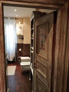 La salle de bains est pourvue de toilettes et d'une porte en bois. dans l'établissement Casa di Emma, à Rome