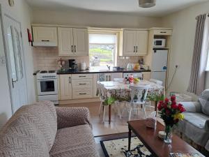 cocina y sala de estar con mesa y sillas en Doolin Farm Apartment en Doolin