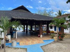 einem Pavillon mit einem Tisch und Stühlen vor einem Haus in der Unterkunft Binubusan Beach Hotel and Resort in Lian