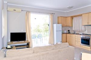 a living room with a couch and a kitchen at Barbaras Apartments in Kato Daratso