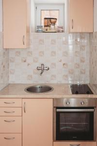 a kitchen with a sink and a stove at Apartments Tončica in Božava