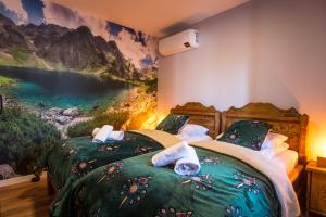 two beds in a bedroom with a painting on the wall at Apartament Luna Góralka in Zakopane