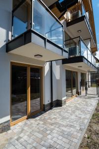 a house with glass doors and a balcony at Apartament Luna Góralka in Zakopane