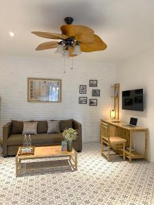 uma sala de estar com um sofá e uma ventoinha de tecto em Song Anh Indochina Studios Pasteur em Ho Chi Minh