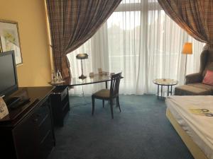a hotel room with a desk and a bed at Akzent Hotel Höltje in Verden