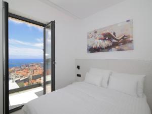 a bedroom with a white bed and a large window at Luxury Amarin Apartment in Dubrovnik