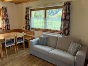 a living room with a couch and a table at App. Daverda Walter Strada al Plan Dessora 26 in San Vigilio Di Marebbe