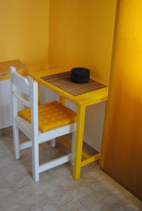 a yellow table and a chair with a bowl on it at Karmik Concept Apartments in Afantou