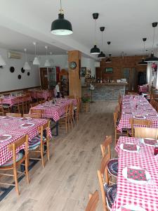 a dining room with red and white checked tables and chairs at Fruškogorski Đeram in Grgeteg