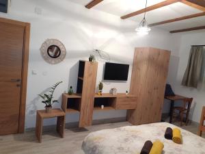 a bedroom with a bed and a desk with a television at Fruškogorski Đeram in Grgeteg