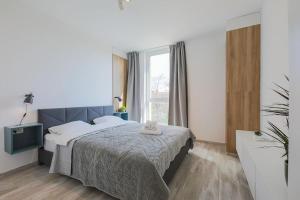 um quarto com uma cama e uma grande janela em Luxury Apt. Near River & Parking em Timisoara