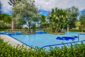 een groot blauw zwembad met bomen op de achtergrond bij Cozy Sorrento Apartment in Sorrento