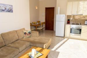 a living room with a couch and a kitchen at Barbaras Apartments in Kato Daratso