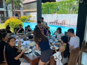 een groep mensen die rond een tafel eten bij Christima Residence in Negombo