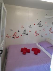 1 dormitorio con 1 cama con mariposas en la pared en Apartments Dalamar en Babino Polje