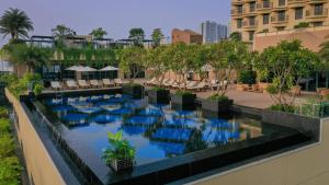 a swimming pool on the side of a building at SUN & MOON, Riverside Hotel in Phnom Penh
