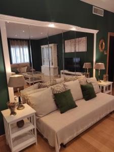 una sala de estar con un sofá blanco con almohadas verdes en El Rincón de Arles, en Jerez de la Frontera