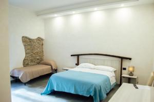 1 dormitorio con 1 cama y 1 silla en Palazzo Iaquinta - Luxury Rooms & Wellness en Cicerale