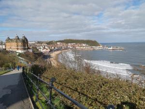 a view of a beach with buildings and the ocean at Scarborough, South Cliff Seaside Garden Apt in Scarborough