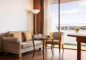 a living room with a couch and chairs and a table at Amari Don Muang Airport Bangkok in Bangkok