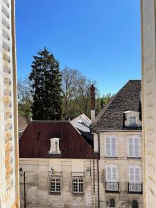 un ancien bâtiment avec des fenêtres blanches et un toit dans l'établissement Loft Marguerite de Bourgogne, à Tonnerre