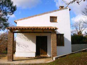 a small white house with a door in a yard at Viviendas Rurales del Robledo in Castaño de Robledo