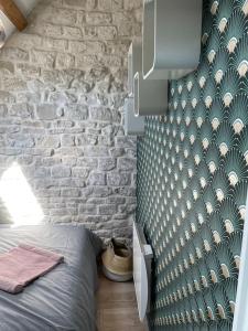 um quarto com uma parede de pedra e uma cama num quarto em Loft Marguerite de Bourgogne em Tonnerre