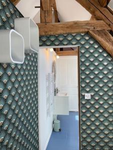 La salle de bains est pourvue d'un mur aux motifs verts et blancs. dans l'établissement Loft Marguerite de Bourgogne, à Tonnerre
