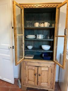 a wooden hutch with bowls and dishes in it at Loft Marguerite de Bourgogne in Tonnerre